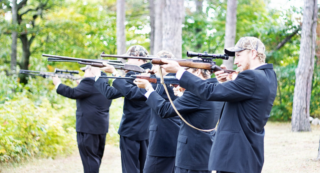 A shot of the groomsmen with guns after the wedding ceremony.